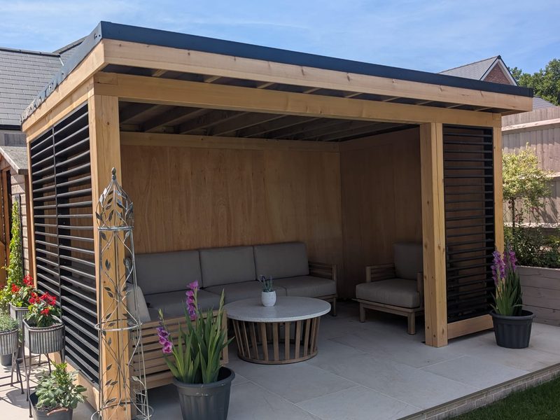 Furnished interior of the bespoke timber garden room with sofas and coffee table