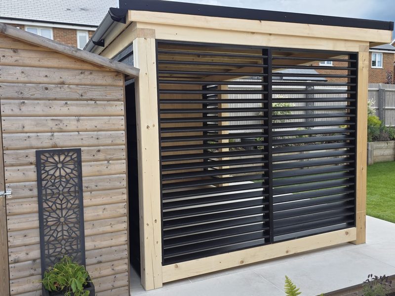 Adjustable black louvred privacy screens on the cedar-framed garden room