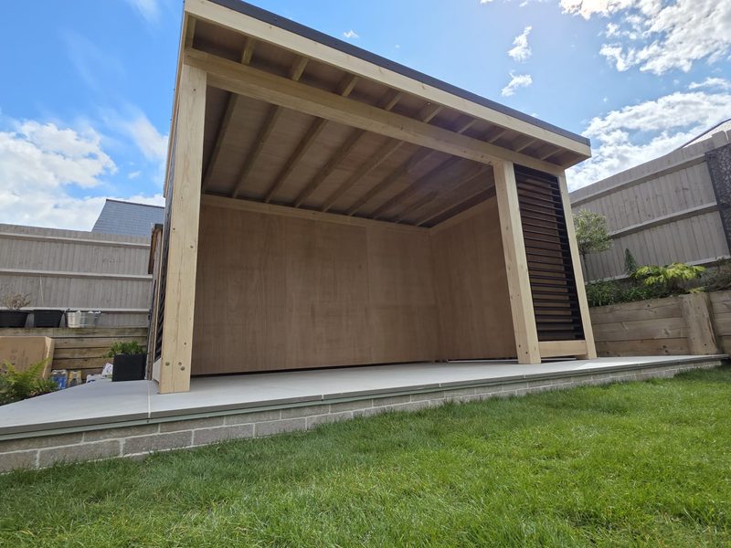 Modern garden room and louvred screen beside the timber shed