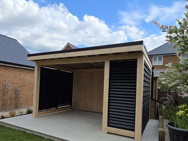 Louvred timber garden room with landscaped border planting